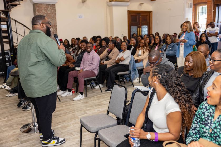 A speaker with the audience at a previous Influence