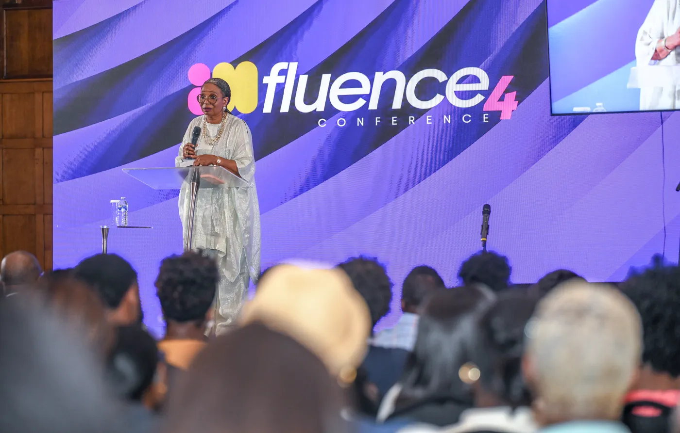Pastor Ibukun Awosika addresses a full room from the lectern
